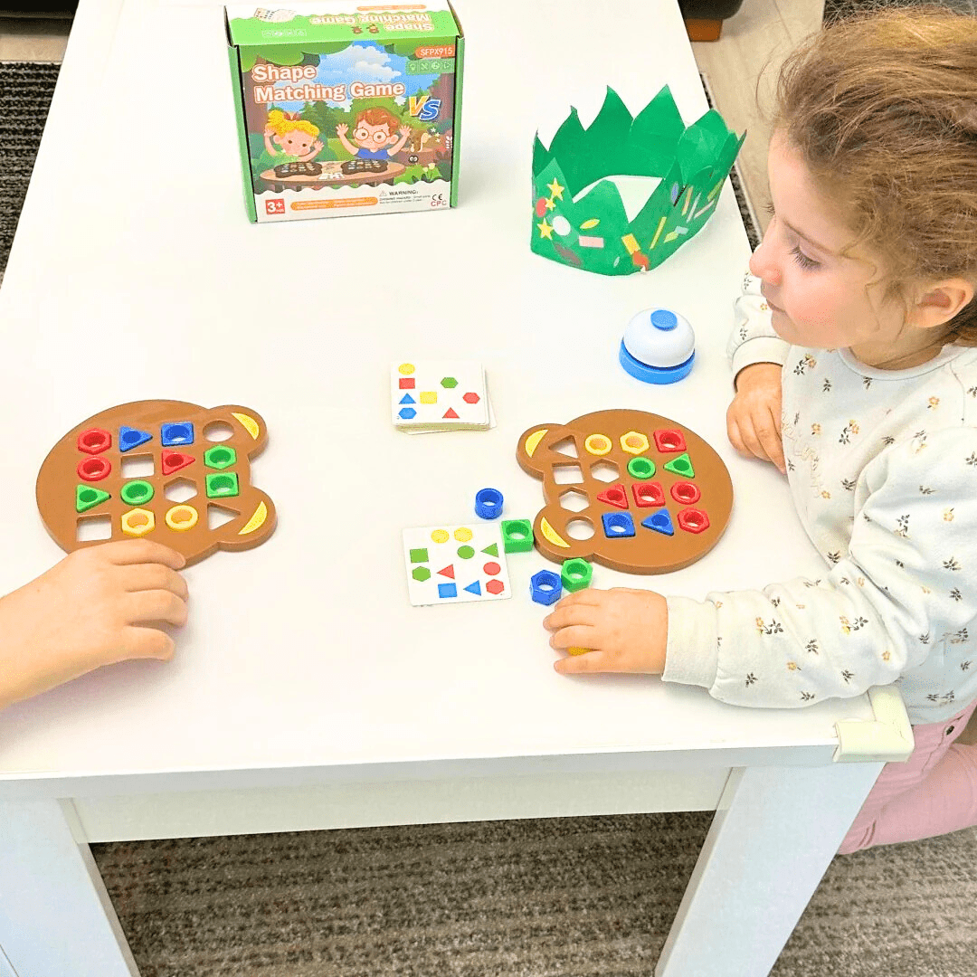 Enfant de 3 ans jouant à un puzzle Montessori géométrique avec formes et couleurs sur une table, jeu éducatif pour développer la logique et la motricité .