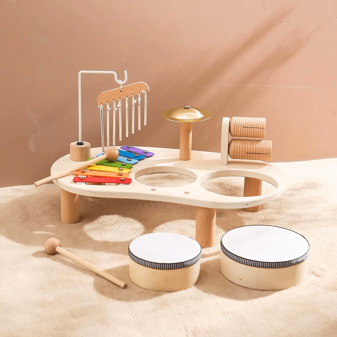 Kit de musique démonté Montessori pour enfant, montrant les tambours retirés de la structure, avec un xylophone arc-en-ciel, une cymbale et des percussions en bois.