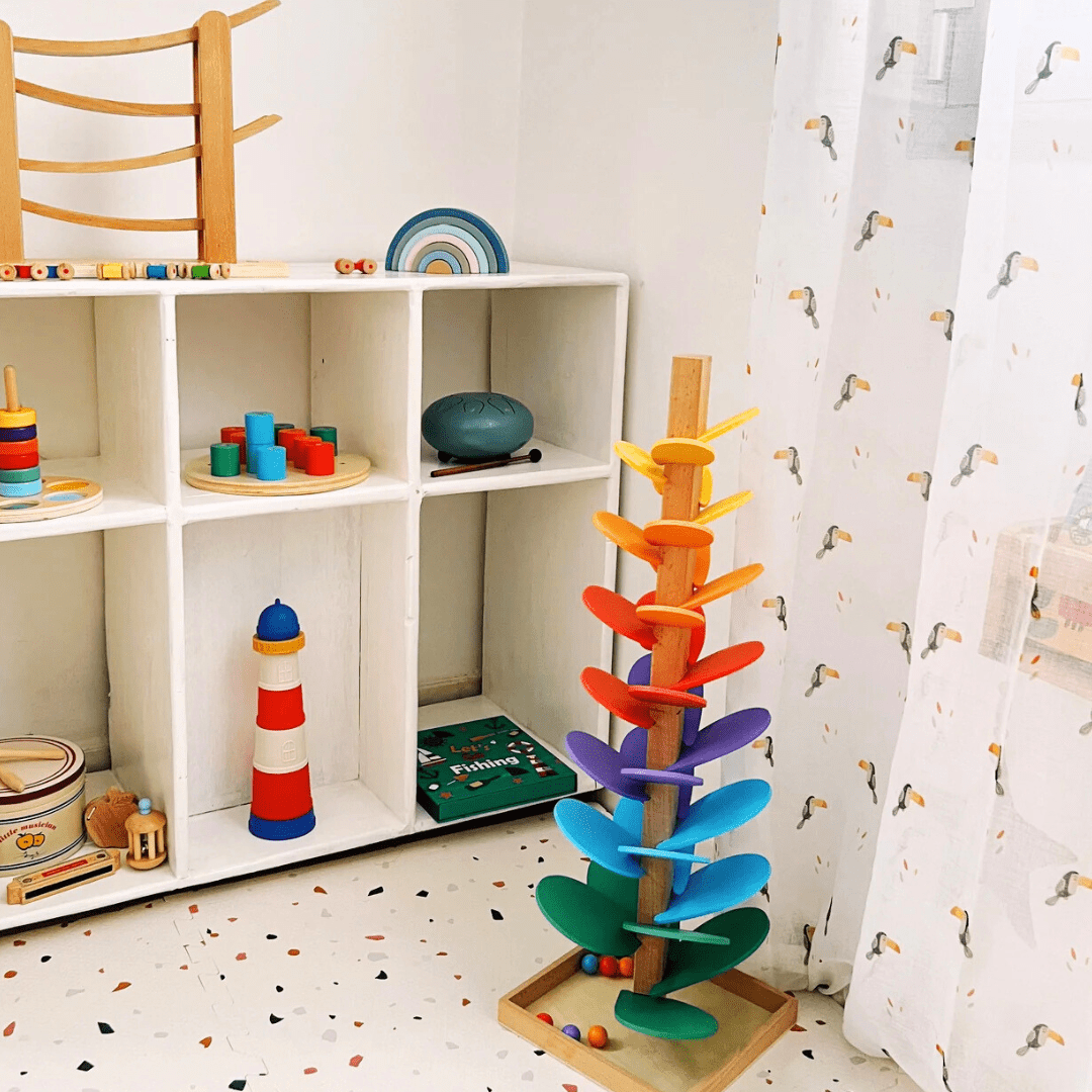 Arbre arc-en-ciel Montessori dans une chambre d’enfant, avec billes en bois colorées à faire descendre