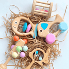 ensemble de hochets montessori colorés en bois sur fond blanc