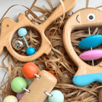 gros plan sur hochets montessori en bois poisson dauphin perles colorées