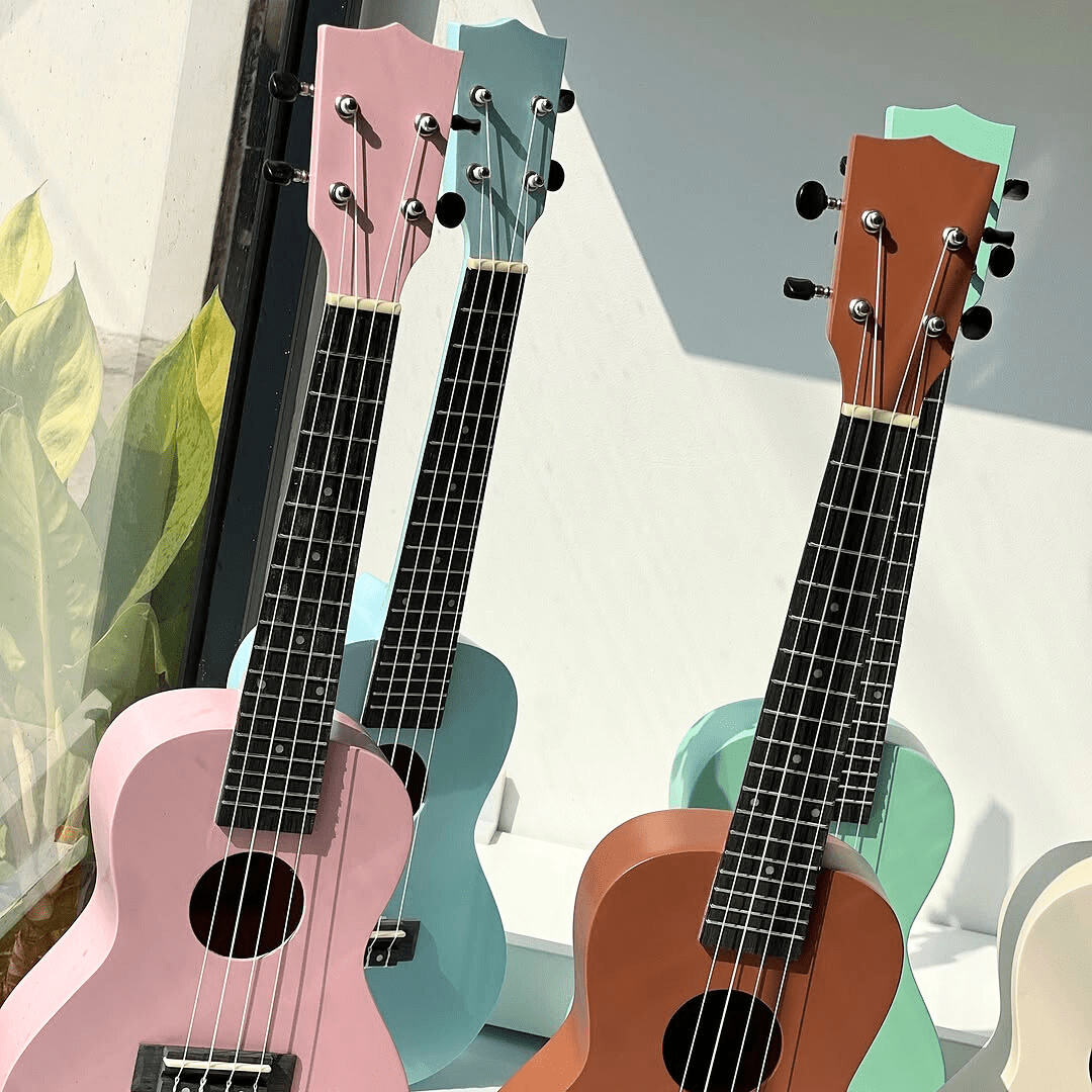 Détail de guitares enfant en bois aux couleurs pastel rose bleu