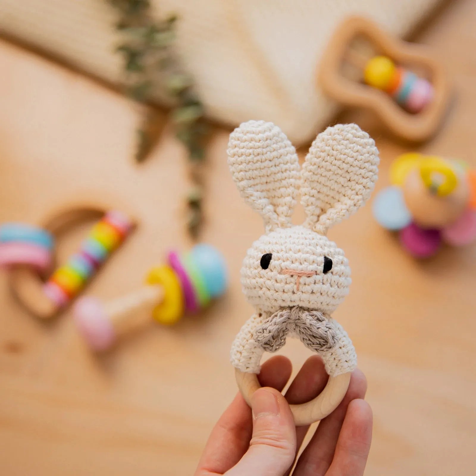 hochet blanc tenu sur les doigts